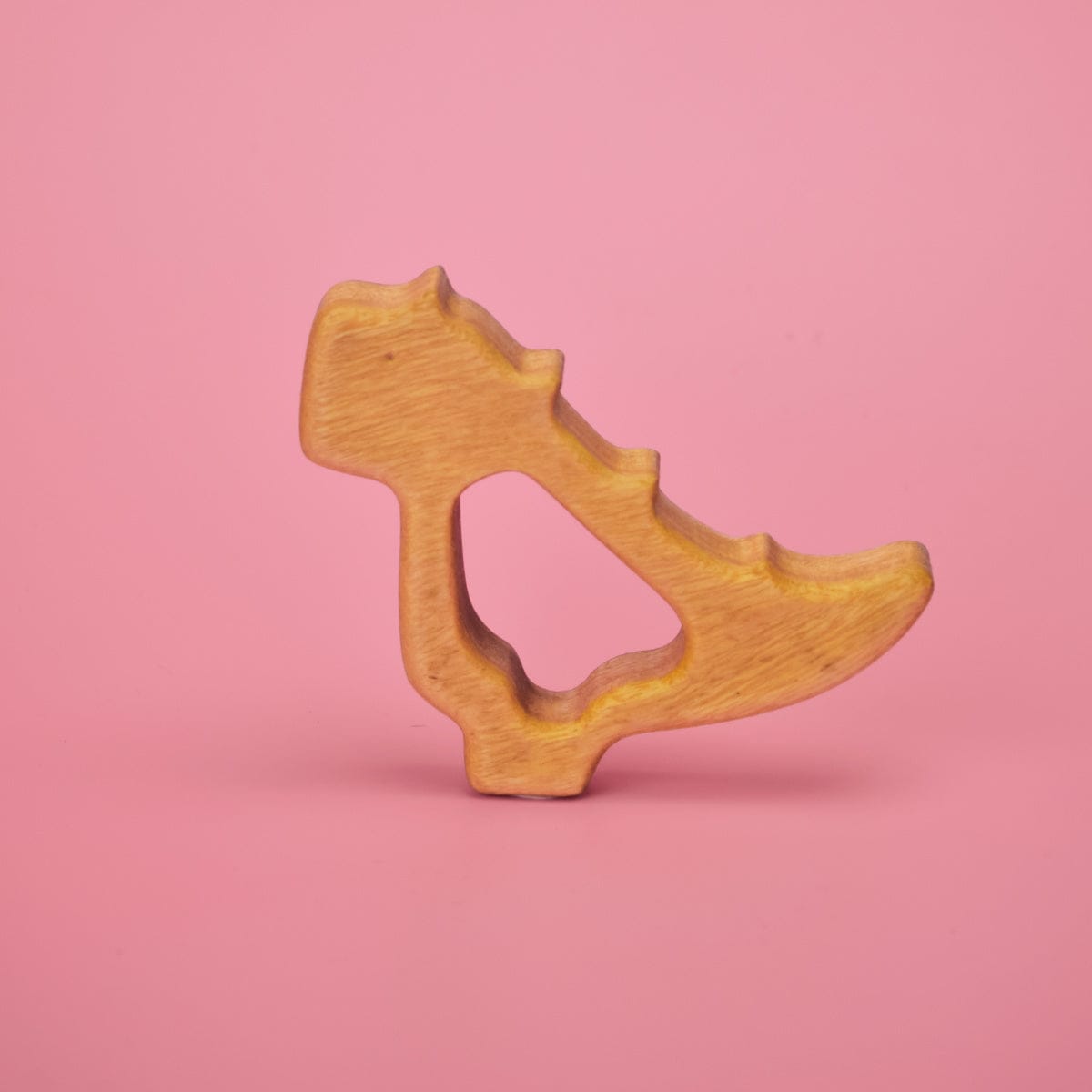 Wooden baby dinosaur teether shaped like a stegosaurus with grip-through hollow center for little hands