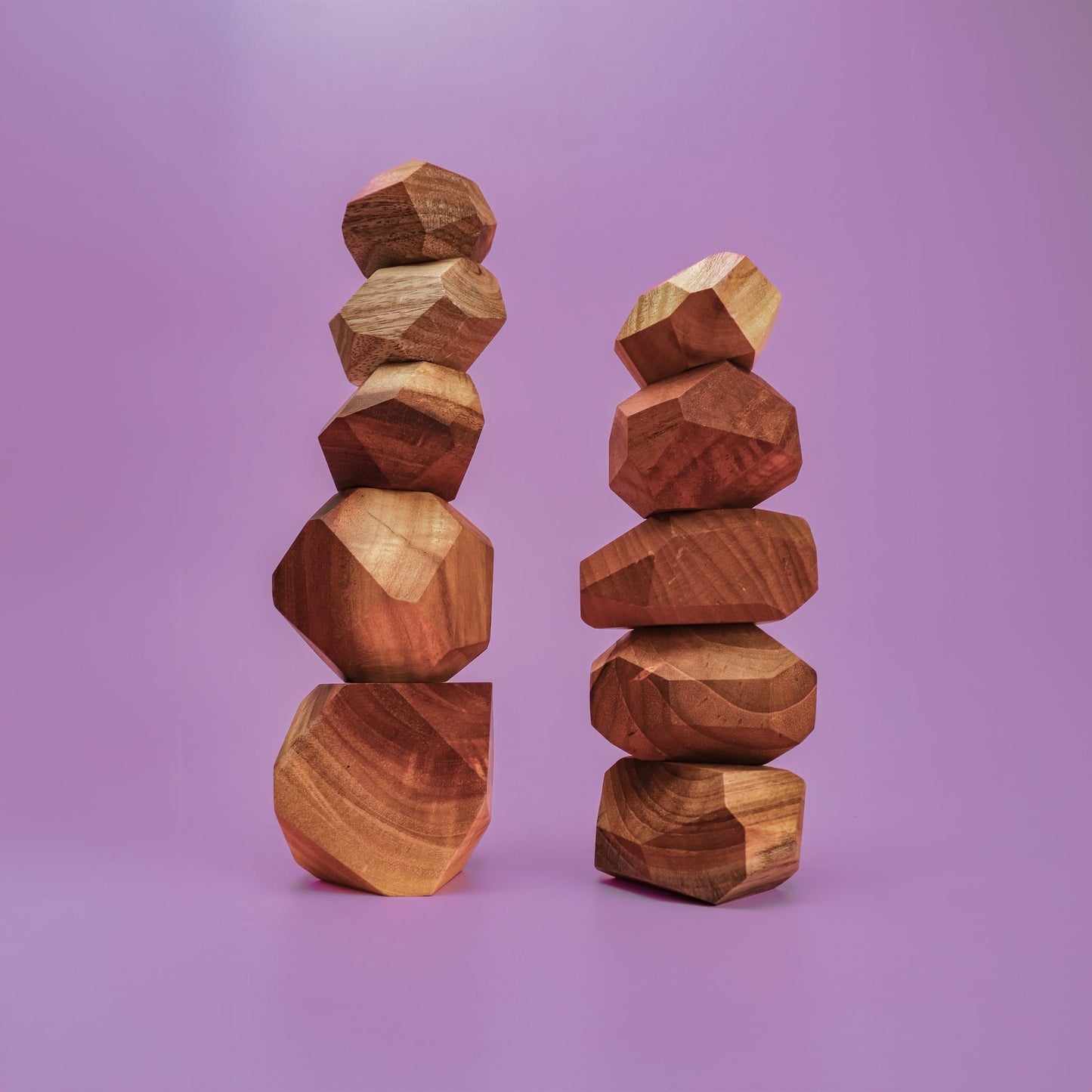 Smol Rocks 10 piece wooden stone set spread out showing faceted irregular shapes and wood tones