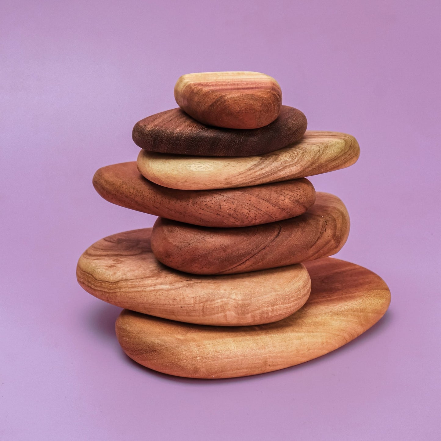 Pebble Build 7 smooth wooden pebble stones stacked in a cairn tower from large to small