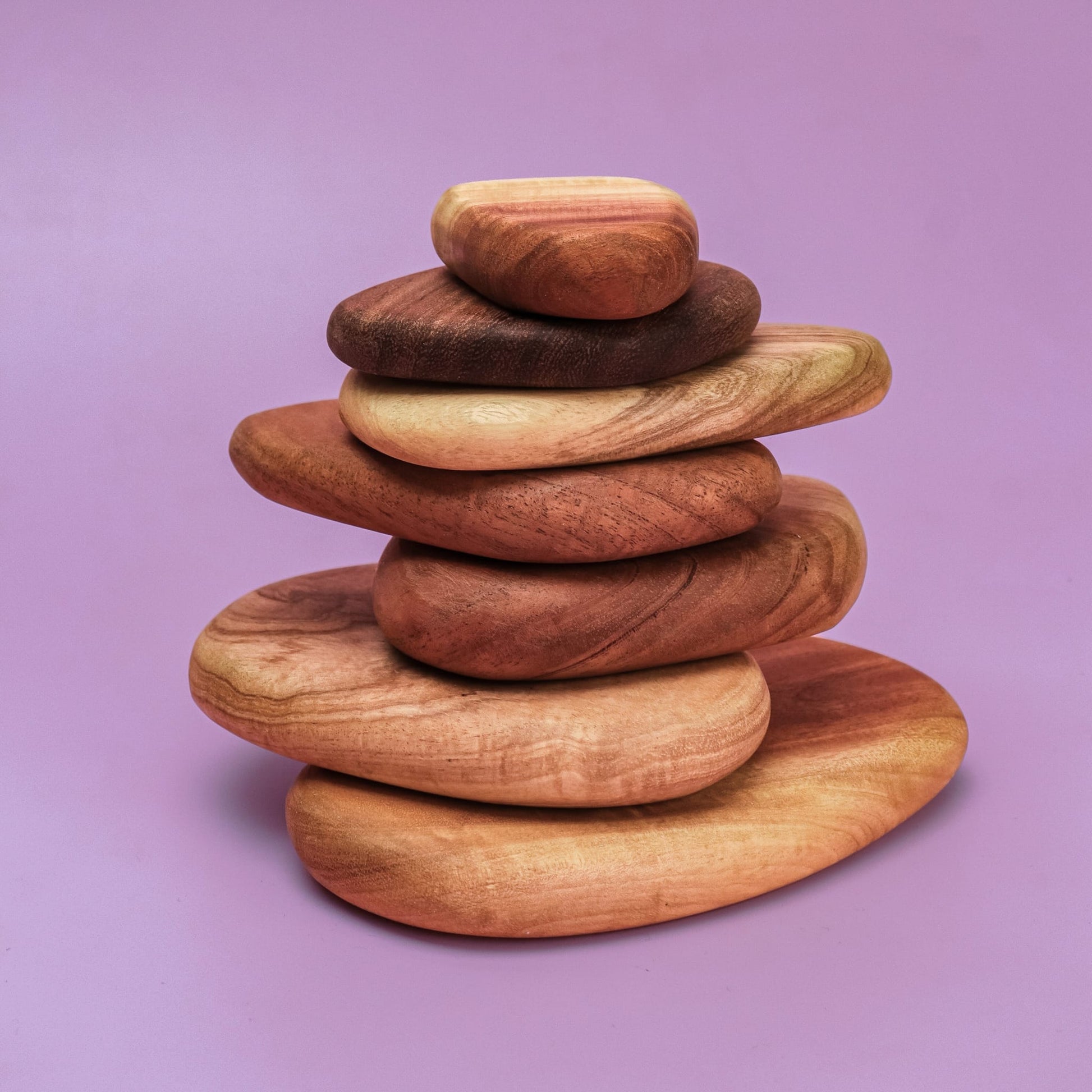 Pebble Build 7 smooth wooden pebble stones stacked in a cairn tower from large to small